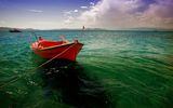 една червена лодка в едно зелено-синьо море ; comments:24